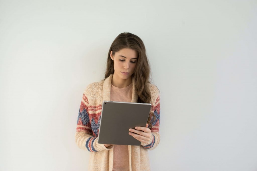 Woman holding ipad taking surveys on respondent as one of the online earning websites for students